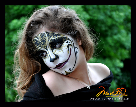 woman in a face painting in black and white featuring a heart between the eyes and an elongated smile